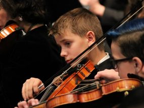 Carter plays violin with orchestra.