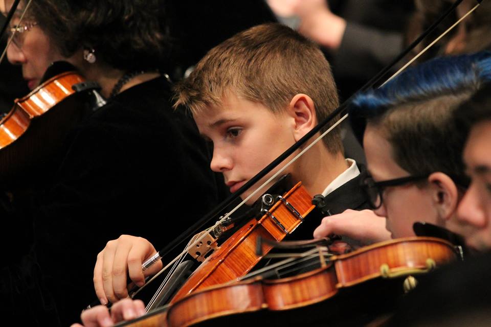 Carter plays violin with orchestra.