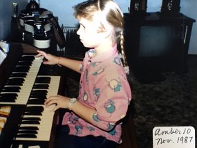 Amber playing the organ in her home - 10 years old.